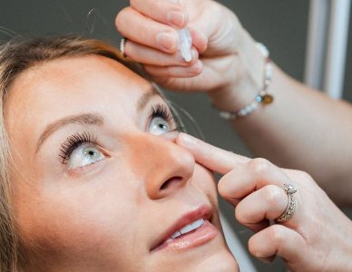 Woman applying Upneeq eye drops